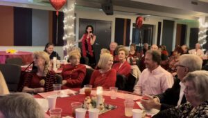 People enjoying a festive holiday gathering with decorations and food.