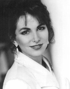 Black and white portrait of a woman smiling gently.